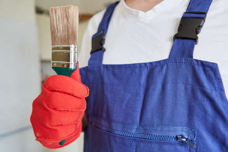 Do-it-yourselfers as a painter or varnisher with a brush to paint and renovate the apartmentの写真素材
