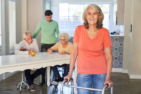 Senior woman with walking aid after a stroke in a nursing home or in rehab learns to walkの写真素材