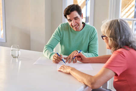 Son helps senior woman fill out contract or insurance at home