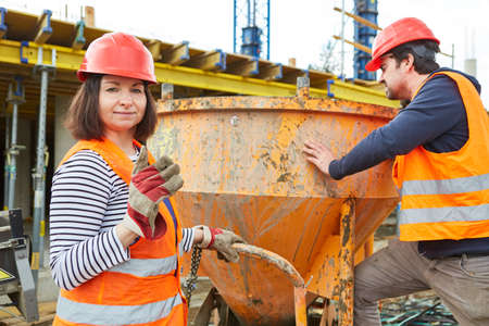 Construction workers team works on cement mixer on the new building construction site for house buildingの写真素材