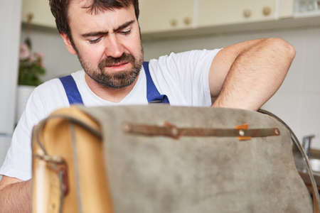 Man as a craftsman from the repair emergency service or handyman in the kitchenの写真素材