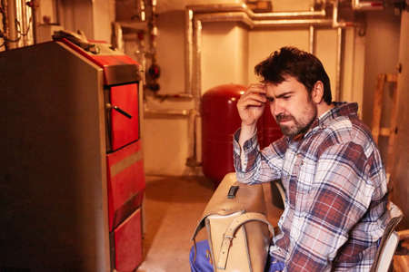 Thoughtful man as a do-it-yourselfer has a problem with the defective heating system