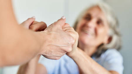 Holding hands of a senior citizen as a symbol of support and comfort in a nursing home or retirement homeの写真素材