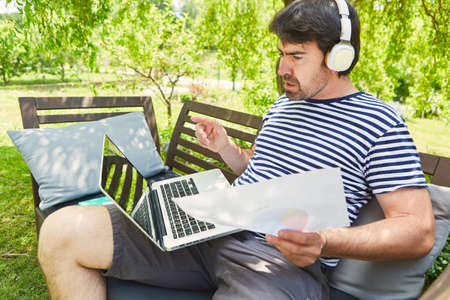 Freelancer in the garden in summer with a video chat or web conference