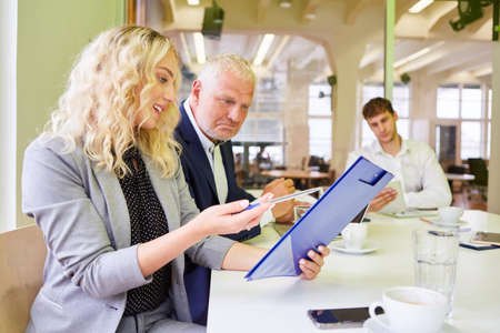Manager and young business woman with checklist discuss the project planning
