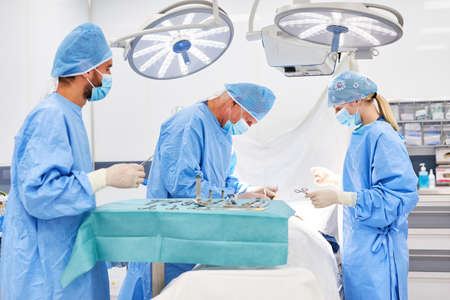Group of surgeons performing an operation on a patient in the operating room of a clinicの写真素材