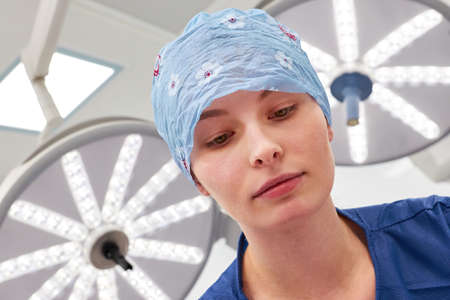 Young woman as a doctor during an internship or as a nurse in the operating theater of the clinic before the operationの写真素材