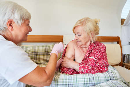 Nurse or doctor vaccinating a senior citizen as protection against infectious diseaseの写真素材