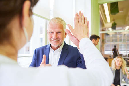 Business team people are happy about a success and get a high fiveの写真素材