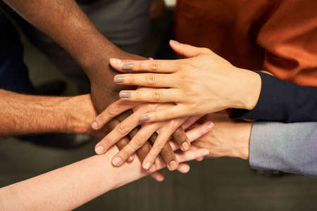 Business team people stacking hands as a symbol for network and team buildingの写真素材