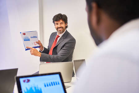 Business consultant as a speaker in a consulting workshop with diagrams and graphics