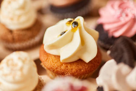 Small cupcake with cream and passion fruit cream as a topping for a birthday partyの写真素材