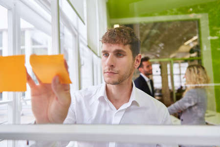 Businessman in the ideas workshop with sticky notes during the evaluation and analysis