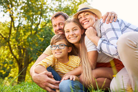 Happy family with two children as a harmonious small family in nature in the park