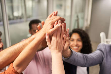 Many hands of business people give high five for team building and motivationの写真素材