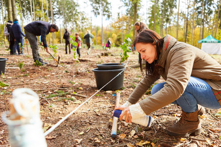 Woman marks a tree pole with a spray can in preparation for reforestation in the forestの写真素材