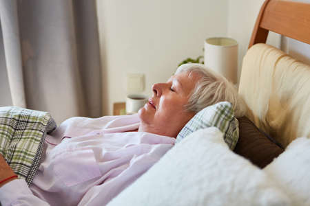 Old woman taking a nap or as a patient in the hospital or at home