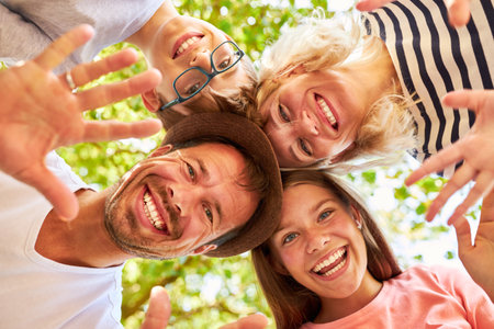 Family with daughter and son stand head to head and wave happily in nature