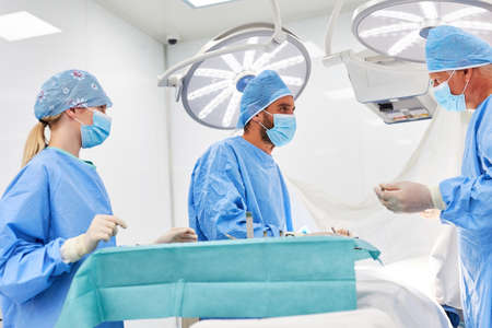 Senior physician and assistant doctor work together in an emergency operation in the operating roomの写真素材