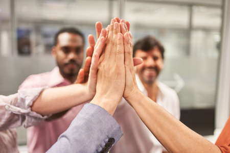 Business people giving the high five as a symbol for team building and motivation