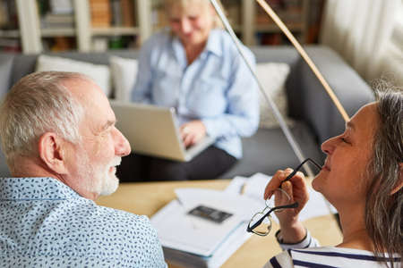Retired senior couple thinking about securing retirement savings with consultant in background