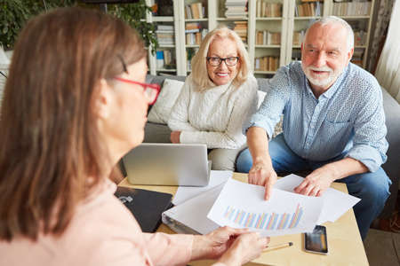 Seniors discuss retirement savings and investment chart with their tax advisorの写真素材