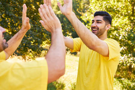 Two young people give a high five as a symbol of motivation and team building