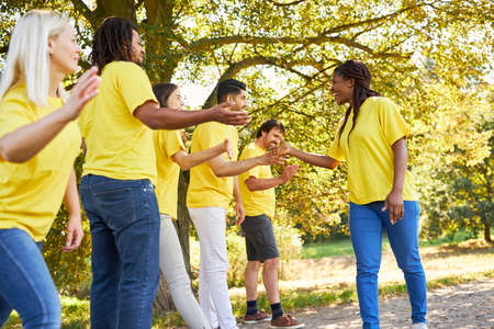 Young people as a team clapping as motivation in the team building workshop
