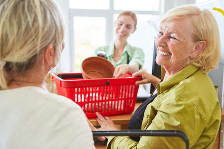 Smiling customer when paying at the checkout of the garden center or hardware store