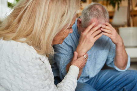 Frustrated man and woman consoling in relationship conflict quarrel at senior home