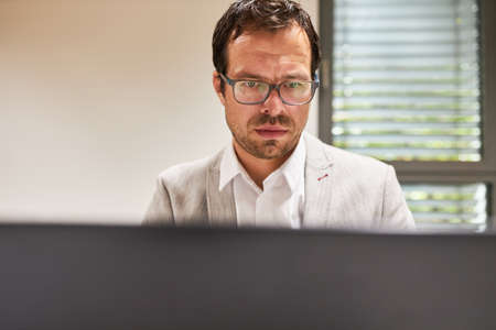 Business man working concentrated on computer online or as programmer in office