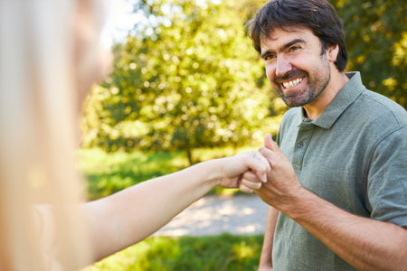 Young man and young woman greet each other with fist bump for motivation and cooperationの写真素材