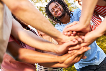 Multicultural group of friends stacking hands for diversity and team buildingの写真素材