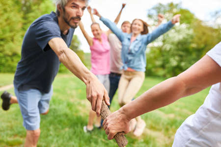 Young man passes the baton to team colleagues in the race at the team eventの写真素材