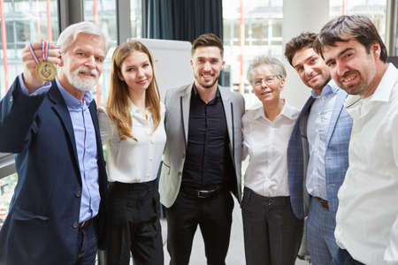 Successful start-up business team with a medal as the proud winners of a competitionの写真素材
