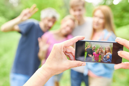 Hands holding smartphone for snapping friends or family on vacation