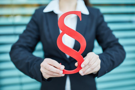 Hands of businesswoman holding big red paragraph symbol as law conceptの写真素材