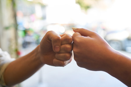 Two hands as fists do the fist bump as a concept for a cool greetingの写真素材