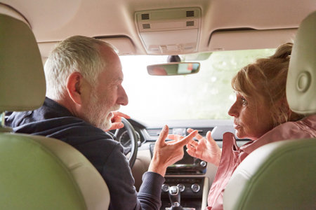 Senior man and woman arguing while traveling in car during road tripの写真素材
