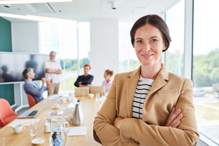 Portrait of smiling businesswoman wearing blazer with arms crossedの写真素材