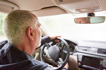 Retired elderly man traveling while driving car during road trip at vacationの写真素材