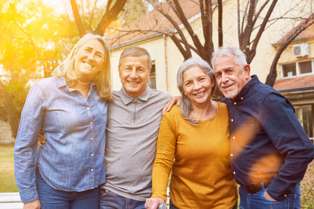 Two happy senior couples as friends group smiling in garden of nursing homeの写真素材