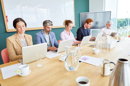 Team of business professionals using laptops in officeの写真素材