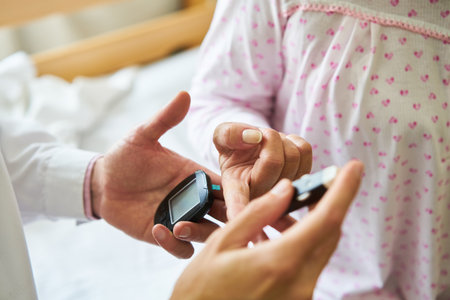 Closeup of male nurse checking blood sugar on finger of diabetic elderly patient in nursing homeの写真素材