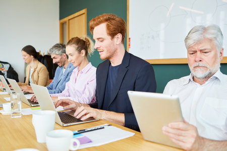 Team of business executives using laptops and tablet PC in officeの写真素材