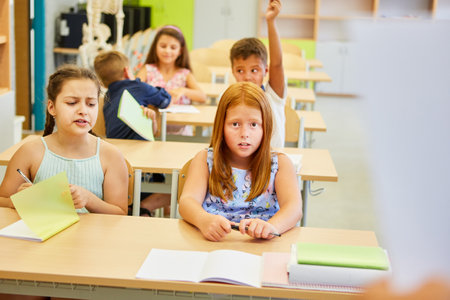 Male and female students studying while sitting together on bench in classroom