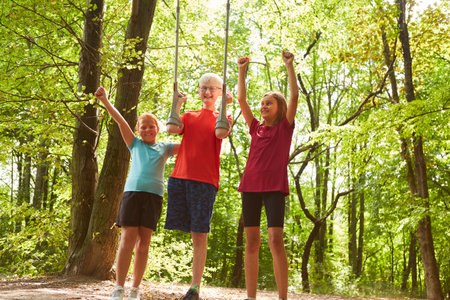Happy female friends cheering with male disabled friend holding crutches while standing in forest
