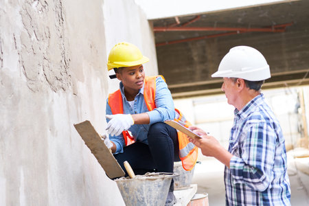 Senior builder discussing with female mason