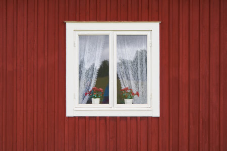 White old wooden window with curtain and flower pots in house wallの写真素材