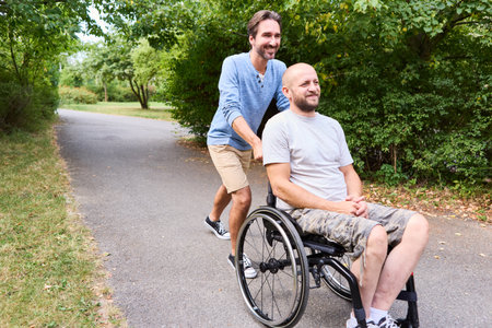 A joyful moment as a person using a wheelchair and his friend share a laugh on a sunny day in the...